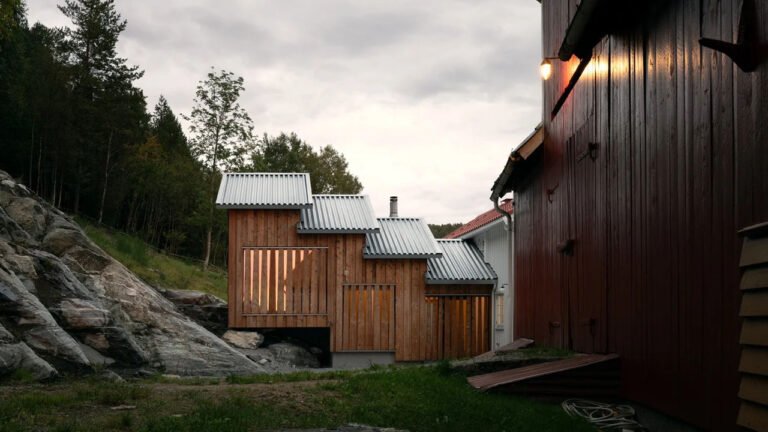 Cascading Timber Extension Appears to Scale Sloped Terrain Behind Norwegian Home